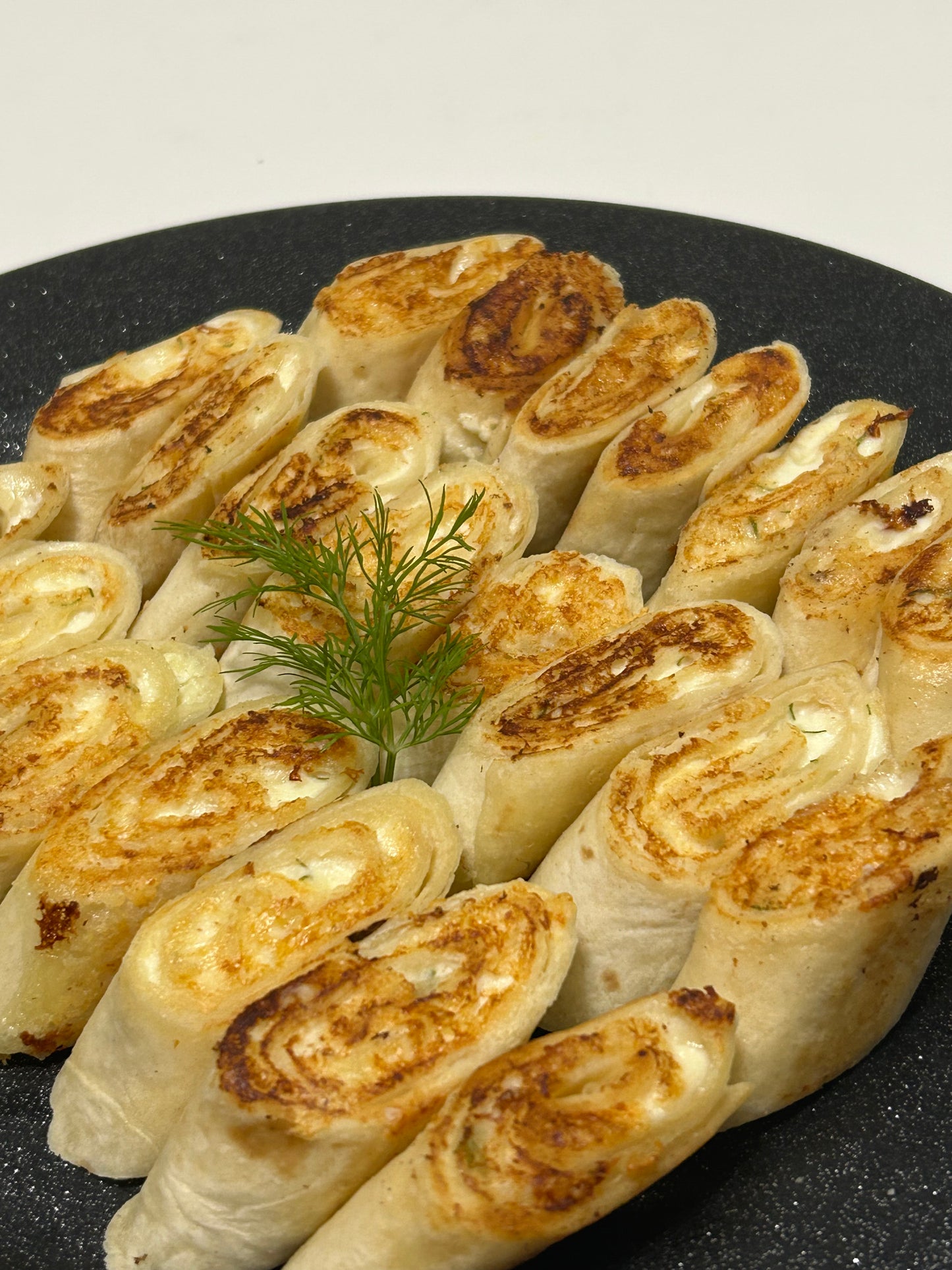 Baked mini tortillas with cheese, farmer cheese and garlic filling platter