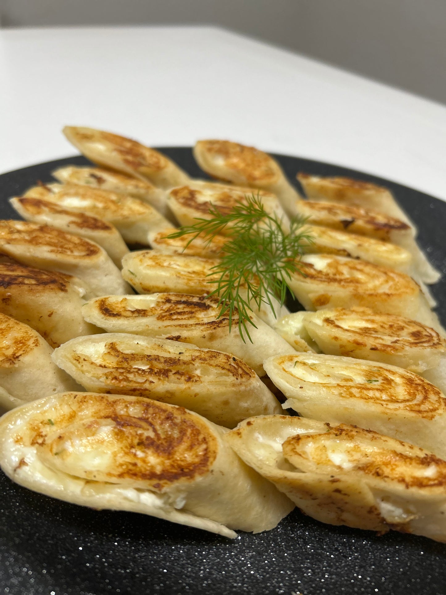 Baked mini tortillas with cheese, farmer cheese and garlic filling platter